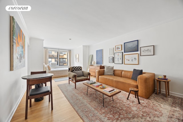 living area featuring baseboards, wood finished floors, visible vents, and ornamental molding