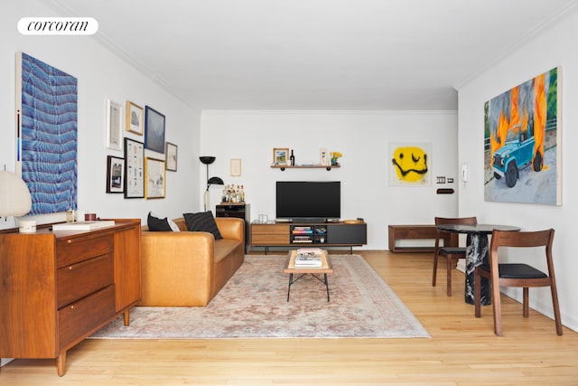 living room featuring light wood-style floors, visible vents, and crown molding