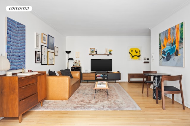 living area with visible vents, light wood-style flooring, and ornamental molding