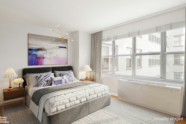 bedroom featuring a notable chandelier and baseboards