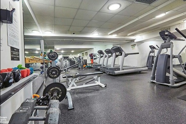 exercise room with a drop ceiling and visible vents