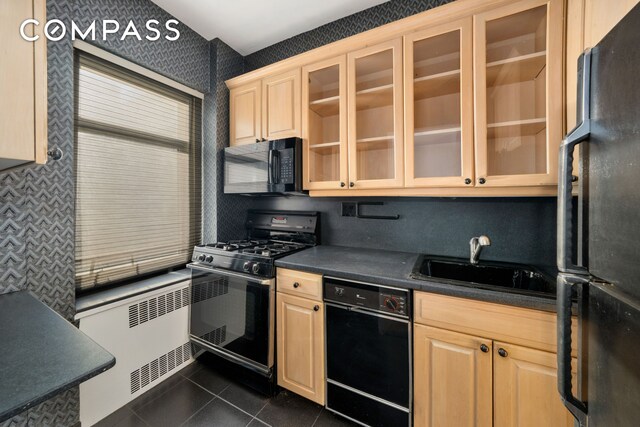 kitchen with dark tile patterned flooring, sink, light brown cabinets, and black appliances