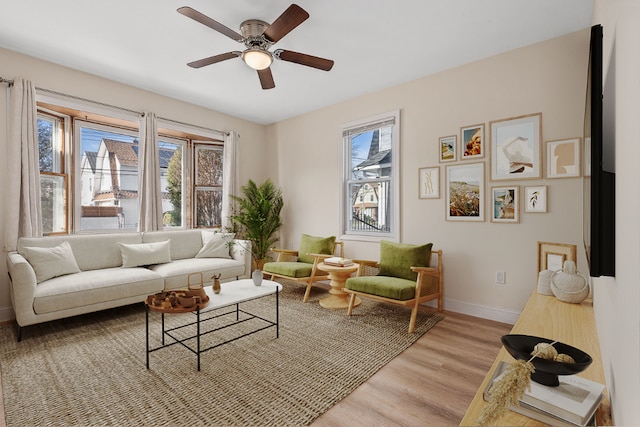 living room featuring ceiling fan, a healthy amount of sunlight, and light hardwood / wood-style flooring