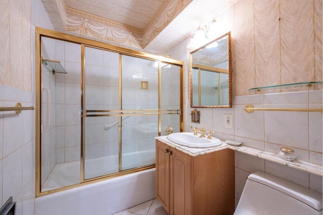 full bath featuring toilet, vanity, decorative backsplash, shower / bath combination with glass door, and tile walls