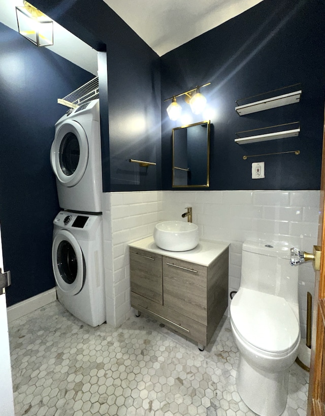 249 Hull St Unit B, New York City, NY 11233 - bathroom featuring stacked washing machine and dryer, tile walls, vanity, and wainscoting