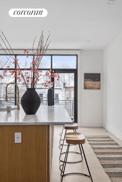 kitchen featuring light wood-type flooring, a breakfast bar area, and sink