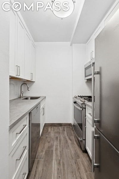 kitchen with sink, white cabinetry, and stainless steel appliances