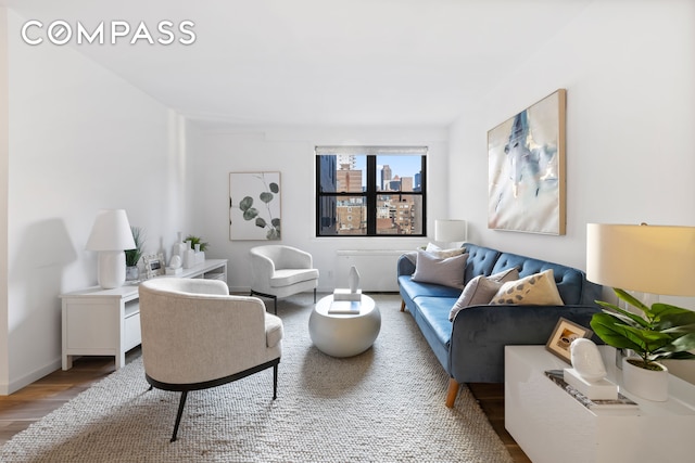 living area with a view of city, baseboards, and wood finished floors