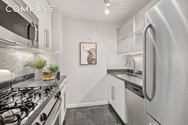 kitchen featuring white cabinetry, sink, dark stone counters, and appliances with stainless steel finishes