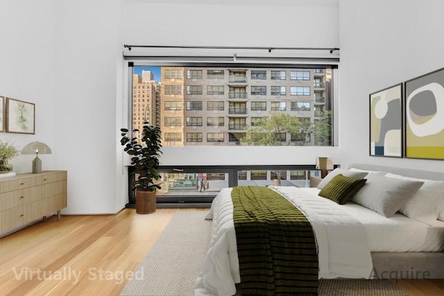 bedroom with wood-type flooring and multiple windows