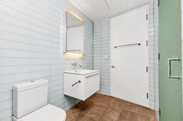 bathroom with tile walls, toilet, tile patterned flooring, and vanity