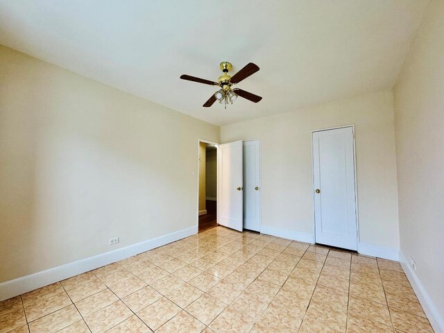 unfurnished bedroom featuring ceiling fan and light tile patterned flooring