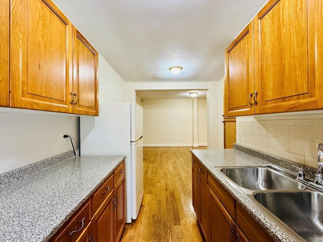 kitchen featuring light hardwood / wood-style flooring, sink, tasteful backsplash, and white refrigerator