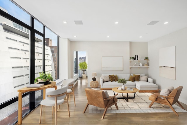 living area with expansive windows, recessed lighting, and wood finished floors