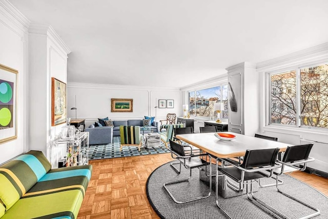 dining area with ornamental molding and light parquet flooring