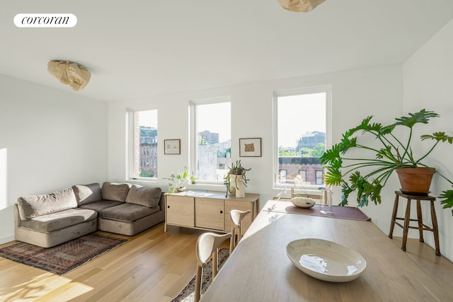 dining space with a view of city, light wood finished floors, and visible vents