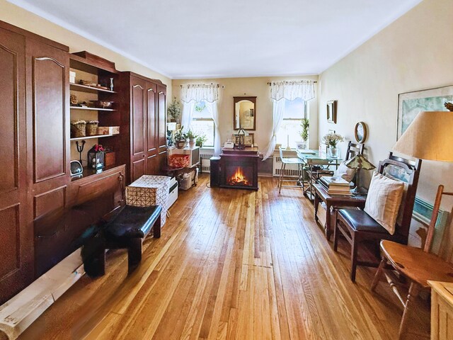 office area with a warm lit fireplace and light wood finished floors