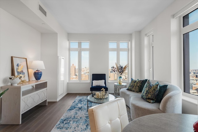 living room featuring visible vents, baseboards, and dark wood-type flooring