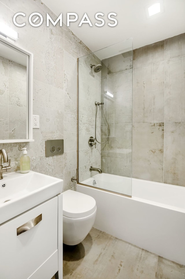 full bathroom with vanity, tile walls, toilet, and shower / bathing tub combination