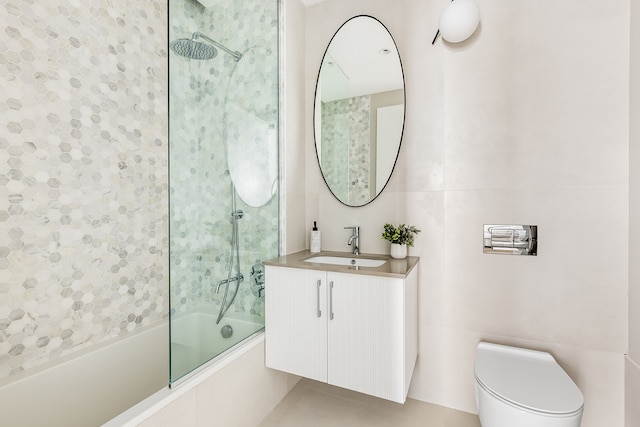 full bathroom featuring vanity, tile walls, toilet, and washtub / shower combination