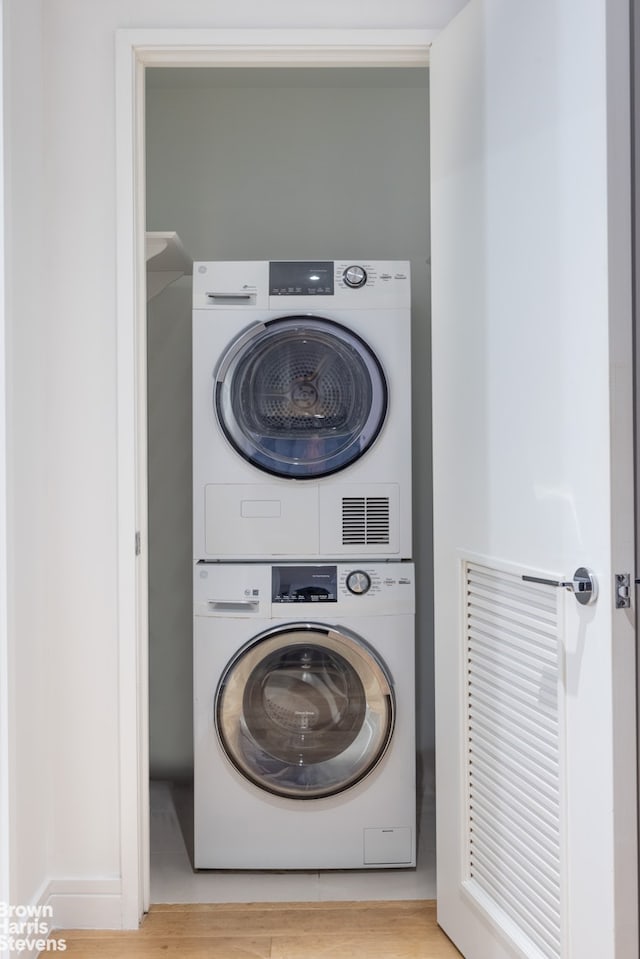 230 E 20th St Unit 23, New York City, NY 10003 - laundry area featuring estacked washer and dryer and wood finished floors