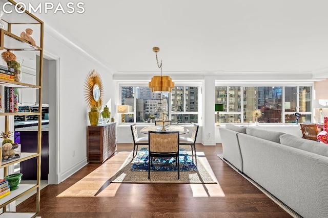 dining area featuring dark wood-type flooring and ornamental molding