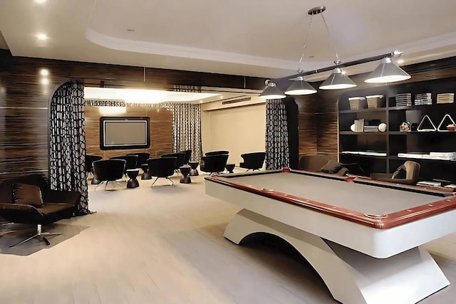 playroom with wooden walls, a tray ceiling, wood finished floors, and pool table