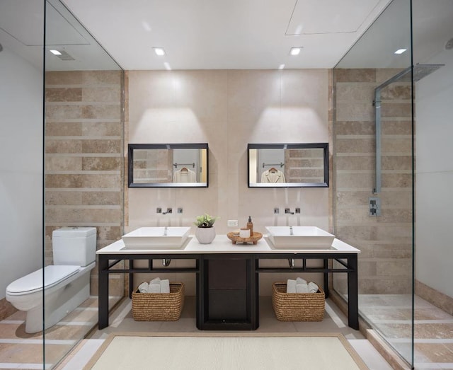 full bathroom featuring a walk in shower, double vanity, a sink, and toilet