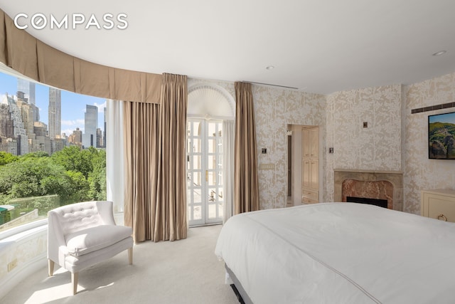 1 E 62nd St Ph, Ph, New York City, NY 10065 - bedroom featuring wallpapered walls, multiple windows, light colored carpet, a skyline view, and a fireplace