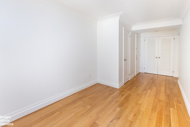 unfurnished living room featuring light hardwood / wood-style floors and ornamental molding