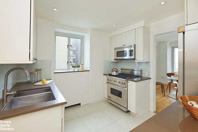200 E 66th St Unit B1804, New York City, NY 10065 - kitchen with appliances with stainless steel finishes, a sink, white cabinets, tasteful backsplash, and recessed lighting