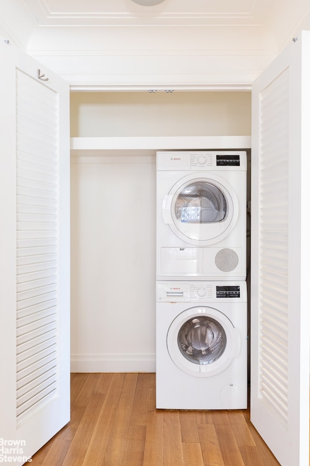 200 E 66th St Unit B1804, New York City, NY 10065 - laundry area with stacked washer and clothes dryer, light wood-style flooring, crown molding, and baseboards