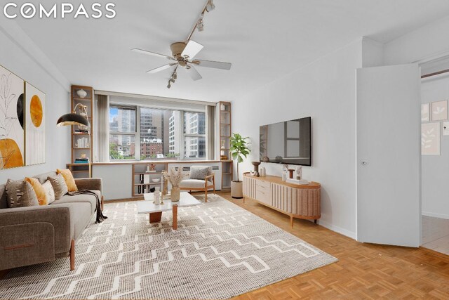 living room featuring parquet floors, track lighting, and ceiling fan