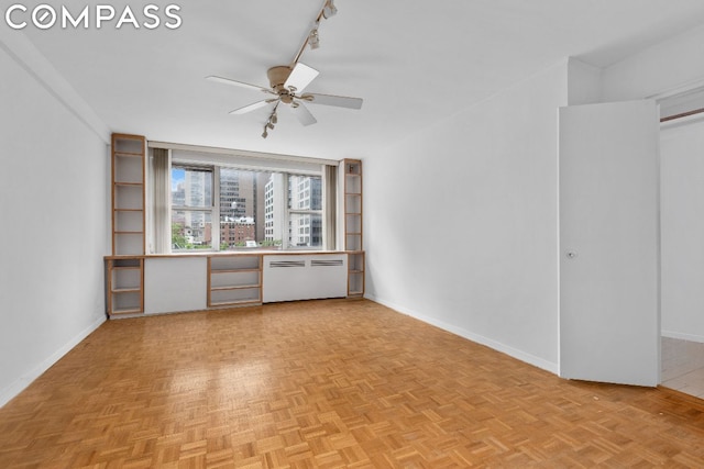 unfurnished living room with ceiling fan, track lighting, and light parquet floors