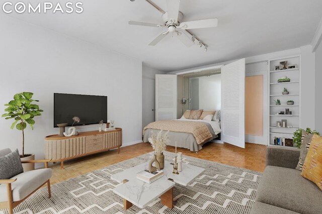 bedroom with light parquet floors, rail lighting, and ceiling fan