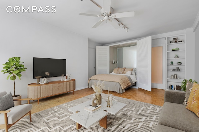 bedroom with baseboards, ceiling fan, and track lighting