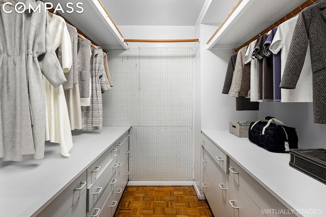 spacious closet featuring dark parquet flooring