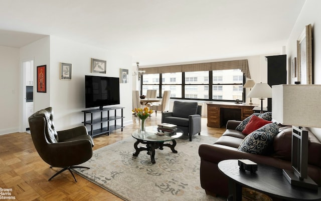 living room featuring light parquet floors and a notable chandelier