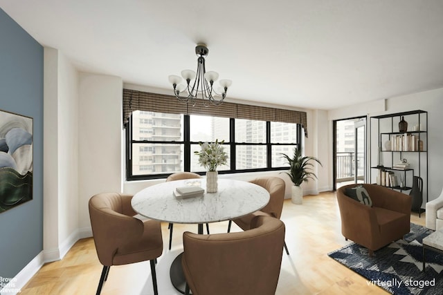 dining area with baseboards, light wood finished floors, and an inviting chandelier