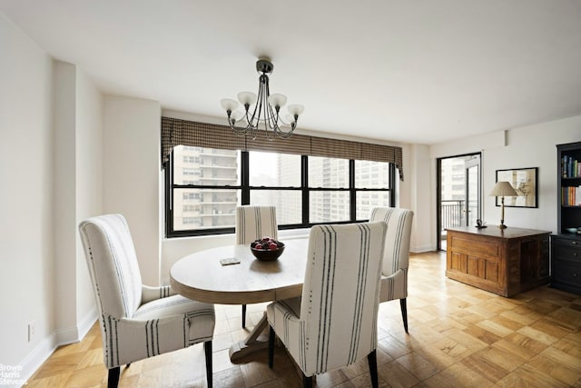 dining room featuring a chandelier and baseboards