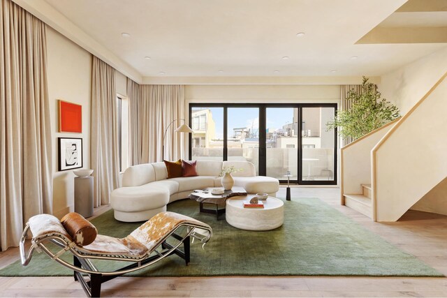 living area featuring stairway and wood finished floors