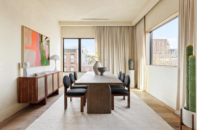 dining area with baseboards and wood finished floors