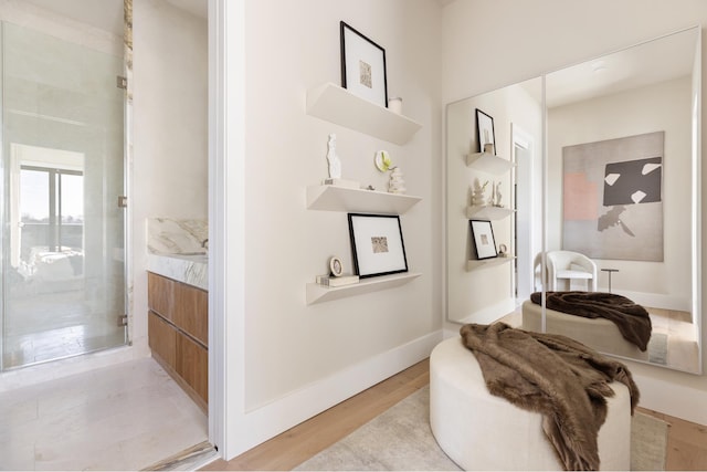 full bathroom with vanity, wood finished floors, a stall shower, and baseboards