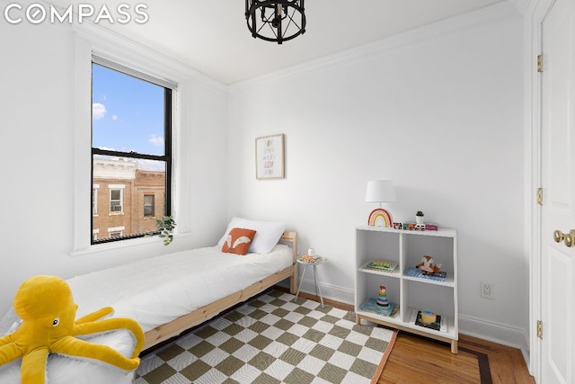 bedroom with crown molding and wood-type flooring