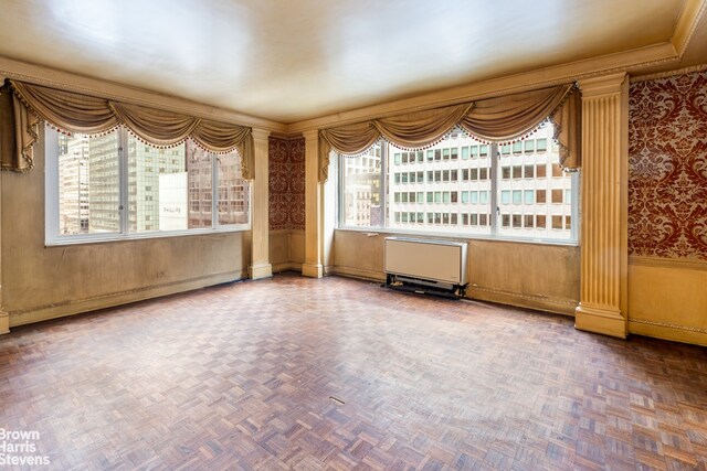 living room with a high end fireplace, parquet flooring, and ornamental molding