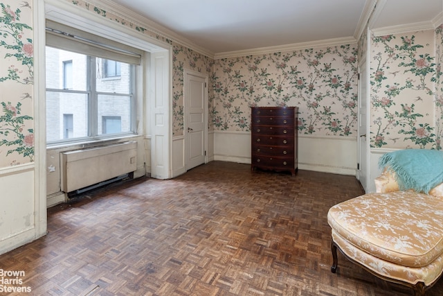 sitting room with wallpapered walls, ornamental molding, radiator heating unit, and wainscoting