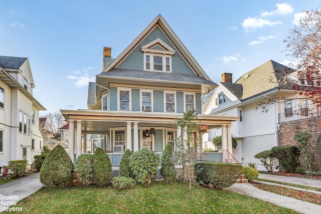 victorian home featuring covered porch and a front yard