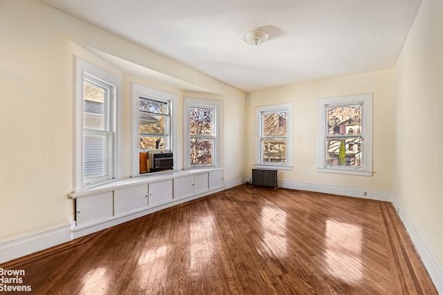 spare room with hardwood / wood-style flooring, a healthy amount of sunlight, and radiator