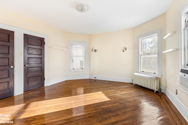 foyer entrance with radiator and hardwood / wood-style floors