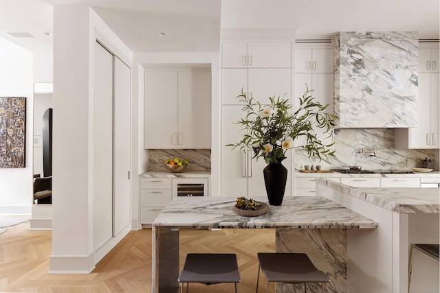 kitchen featuring wine cooler, white cabinets, and decorative backsplash